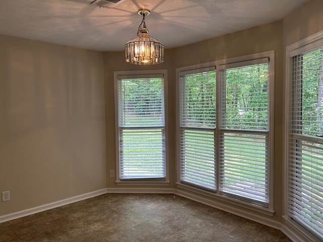 unfurnished dining area with an inviting chandelier, baseboards, and plenty of natural light