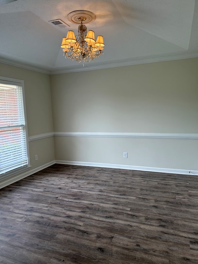 spare room featuring an inviting chandelier, crown molding, dark wood-style floors, and visible vents