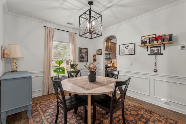 918 Dawkins Ct, Phenix City, AL 36869 - dining space with arched walkways, dark wood-type flooring, ornamental molding, a chandelier, and a wainscoted wall