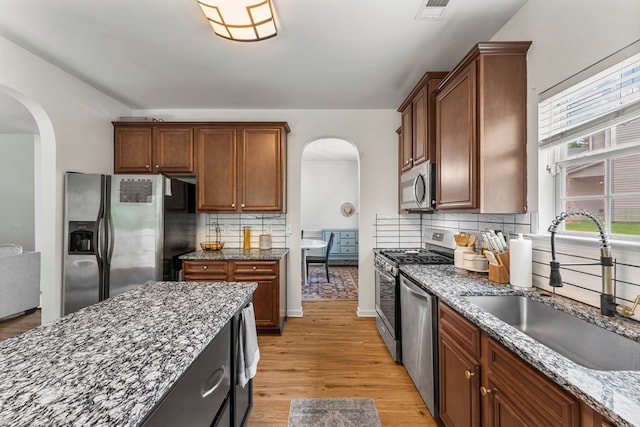 918 Dawkins Ct, Phenix City, AL 36869 - kitchen with stainless steel appliances, arched walkways, a sink, and dark stone counters