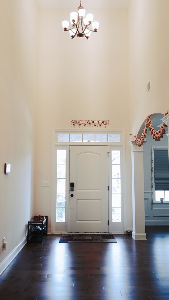 239 Clearbrook Ln, Columbus, GA 31904 - entryway with a towering ceiling, a chandelier, dark wood-type flooring, and baseboards