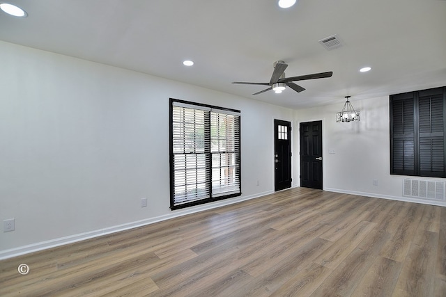 spare room with recessed lighting, wood finished floors, visible vents, and baseboards