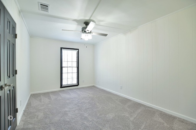 unfurnished room with light carpet, ceiling fan, visible vents, and crown molding