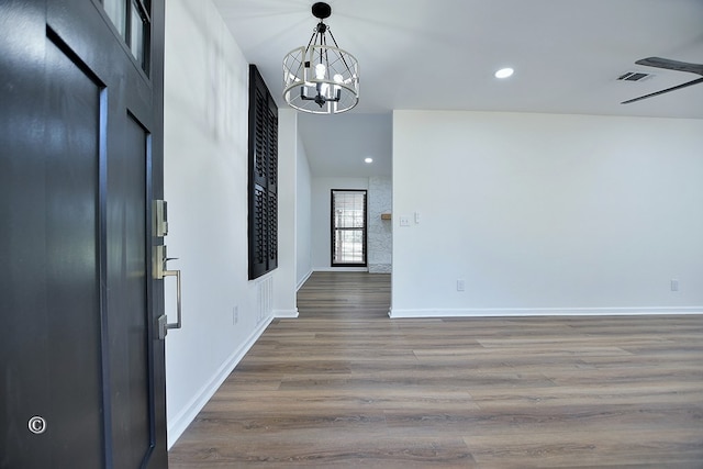 foyer entrance with a notable chandelier, recessed lighting, wood finished floors, visible vents, and baseboards