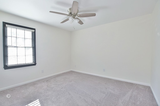 empty room with carpet flooring, ceiling fan, and baseboards