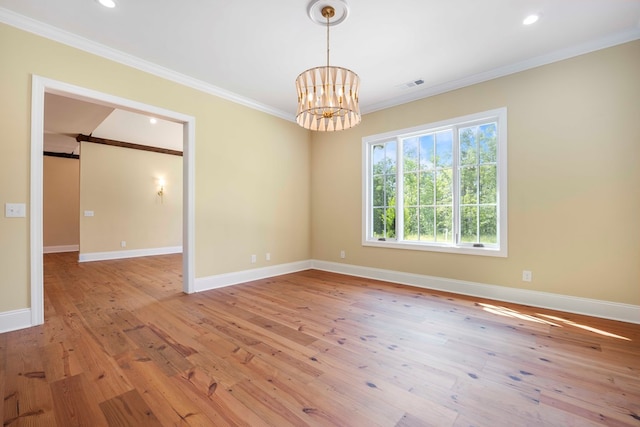 spare room with light hardwood / wood-style flooring, a chandelier, and ornamental molding