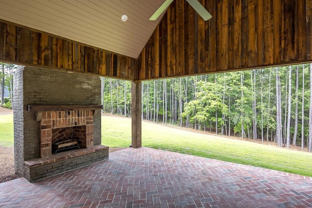 view of patio / terrace featuring ceiling fan and an outdoor stone fireplace