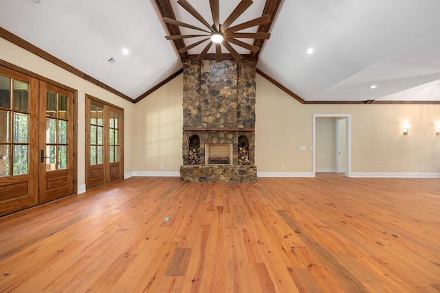 unfurnished living room with beam ceiling, french doors, a stone fireplace, high vaulted ceiling, and light wood-type flooring