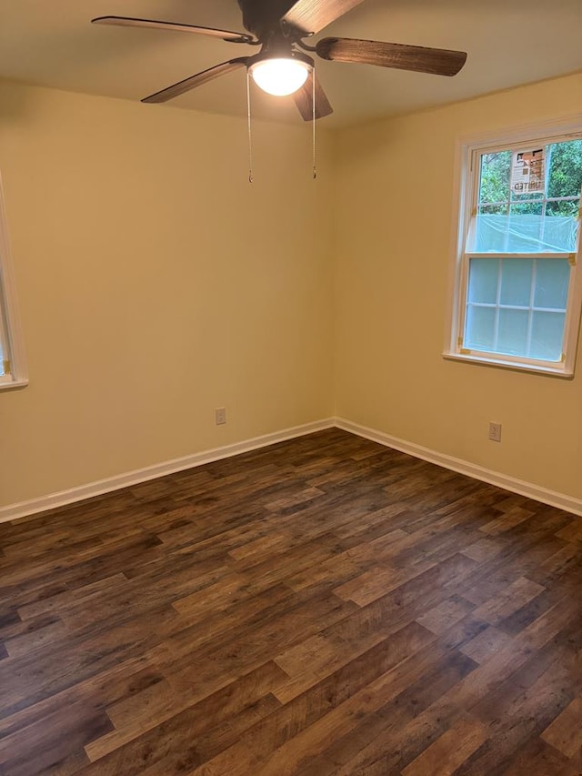 spare room featuring ceiling fan and dark wood-type flooring