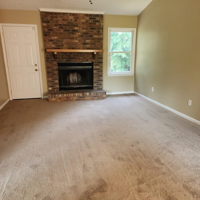 unfurnished living room with carpet, baseboards, and a fireplace