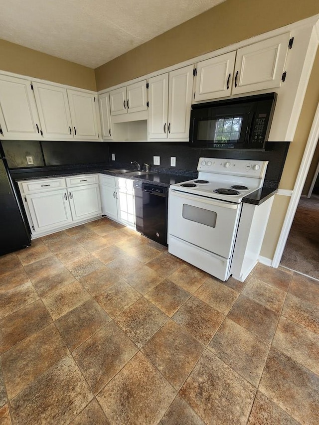 kitchen featuring black appliances, stone tile flooring, dark countertops, and white cabinetry