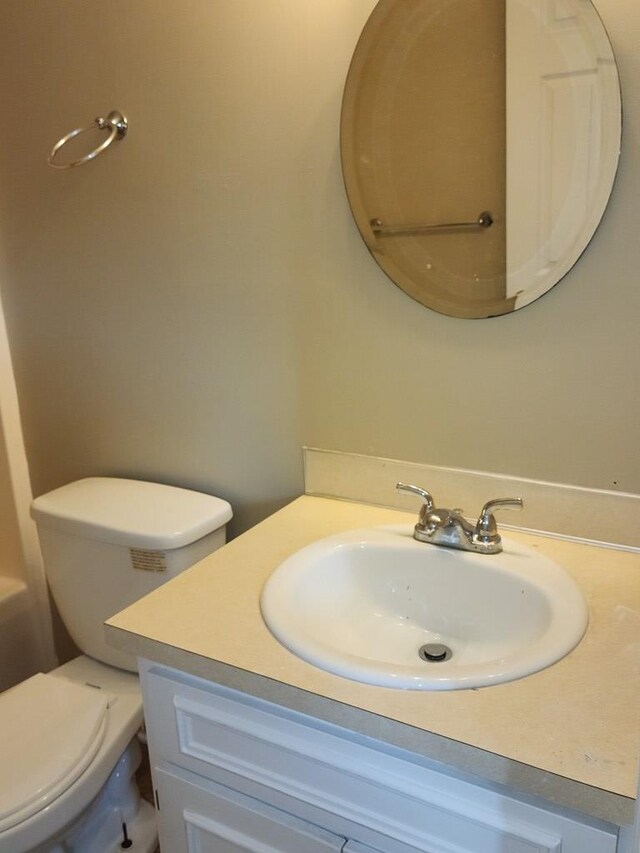 half bathroom with vanity and toilet
