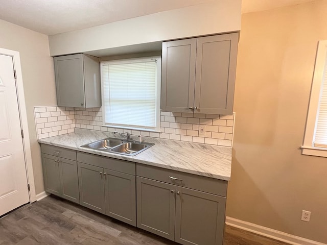 kitchen featuring decorative backsplash, gray cabinets, dark hardwood / wood-style floors, and sink