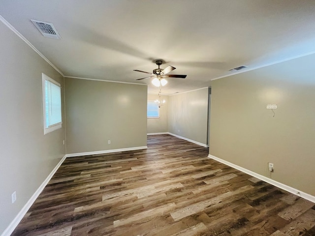 unfurnished room with crown molding, dark wood-type flooring, and ceiling fan with notable chandelier