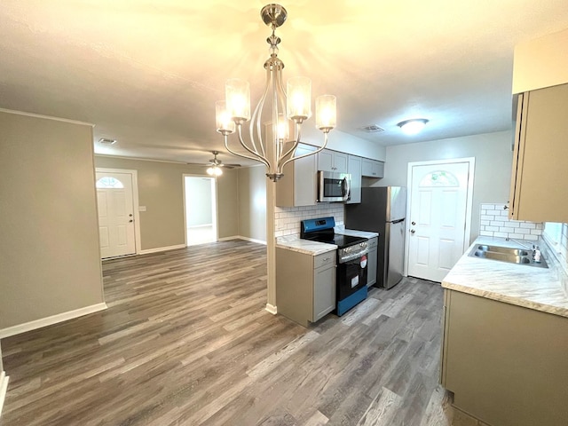 kitchen featuring ceiling fan with notable chandelier, dark hardwood / wood-style flooring, stainless steel appliances, and tasteful backsplash