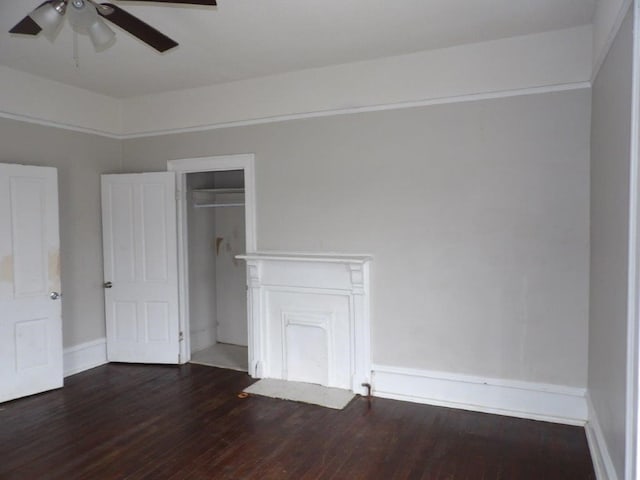 unfurnished bedroom with dark wood-style flooring, a closet, a ceiling fan, and baseboards