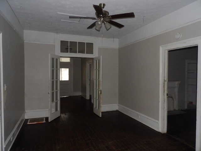 unfurnished room featuring dark wood-type flooring, french doors, baseboards, and a ceiling fan