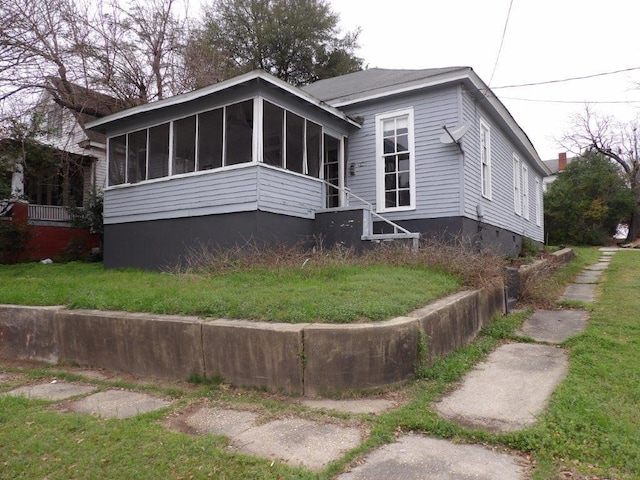 view of front of property with a sunroom and a front lawn