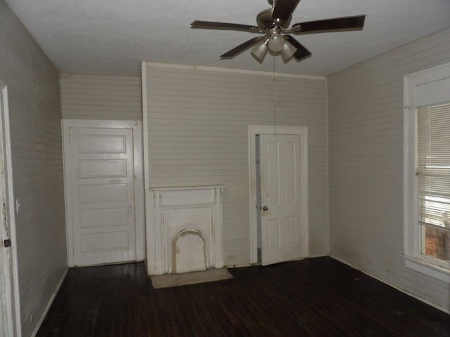 empty room featuring a ceiling fan and dark wood-style flooring