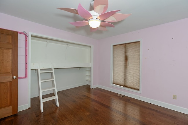 unfurnished bedroom featuring ceiling fan, dark hardwood / wood-style floors, and a closet