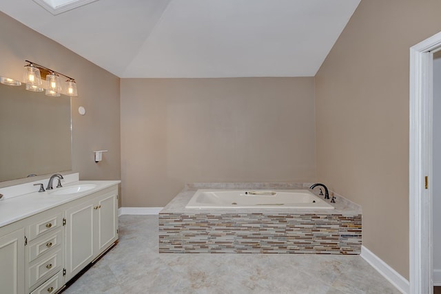 bathroom with vanity, tiled tub, and vaulted ceiling