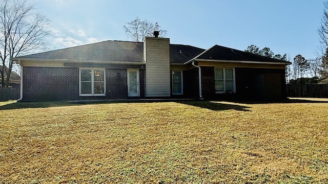 rear view of house featuring a yard