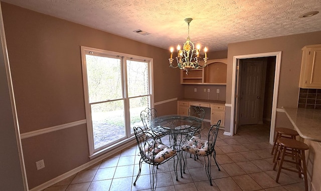 tiled dining room with a textured ceiling and an inviting chandelier