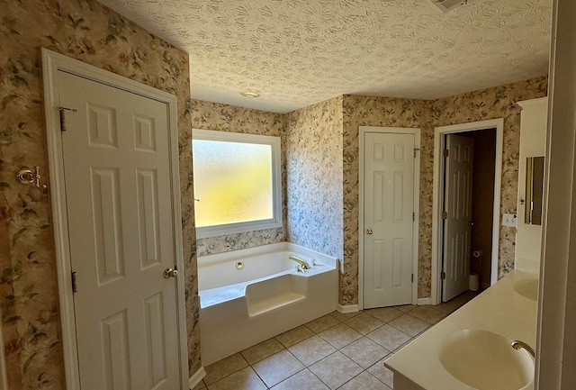 bathroom featuring vanity, tile patterned floors, a textured ceiling, and a tub to relax in