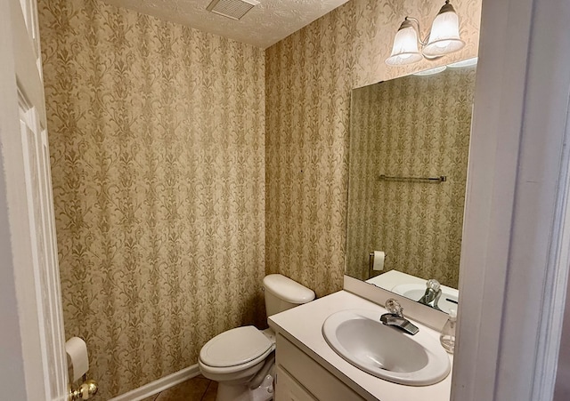 bathroom with tile patterned floors, vanity, toilet, and a textured ceiling