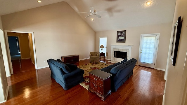 living room featuring dark hardwood / wood-style flooring, a fireplace, high vaulted ceiling, and ceiling fan