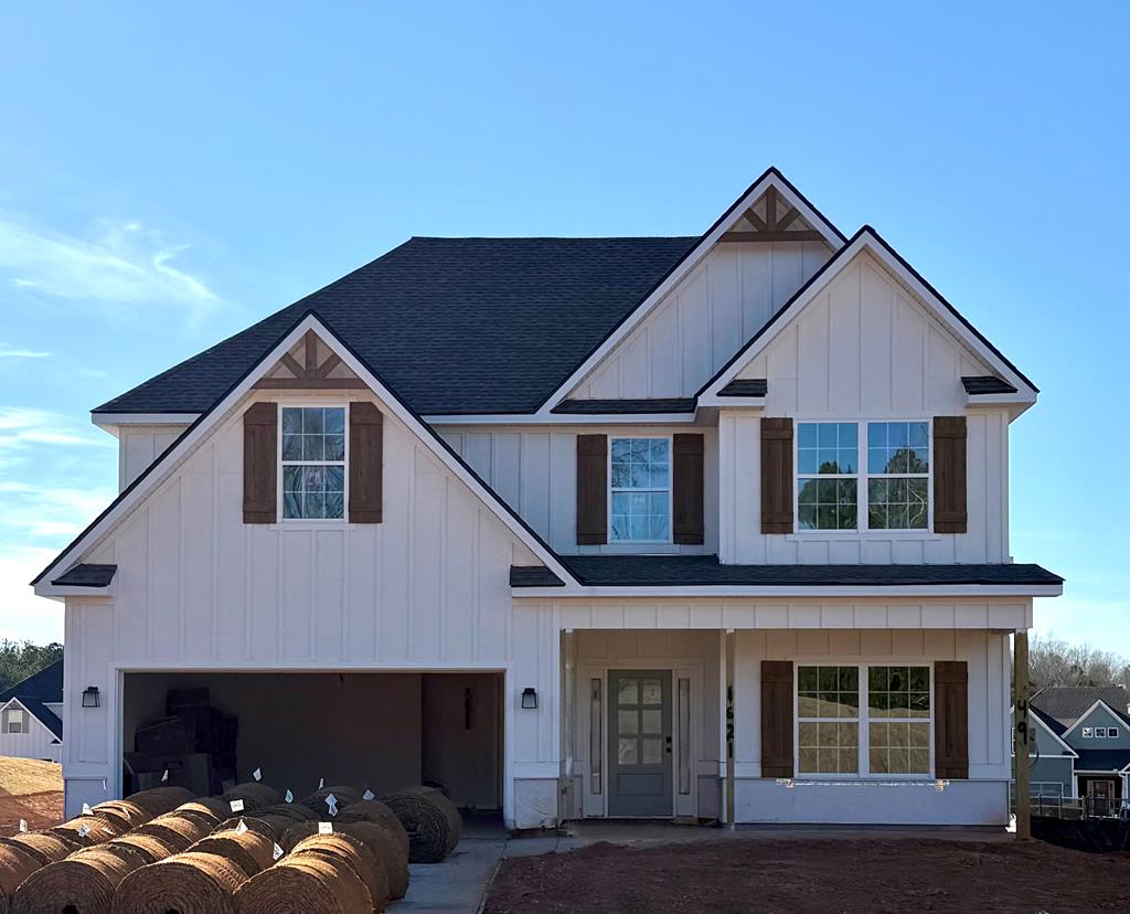 view of front of property with a porch, board and batten siding, an attached garage, and a shingled roof