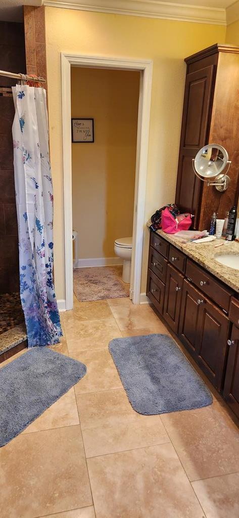 bathroom featuring curtained shower, tile patterned floors, toilet, vanity, and ornamental molding