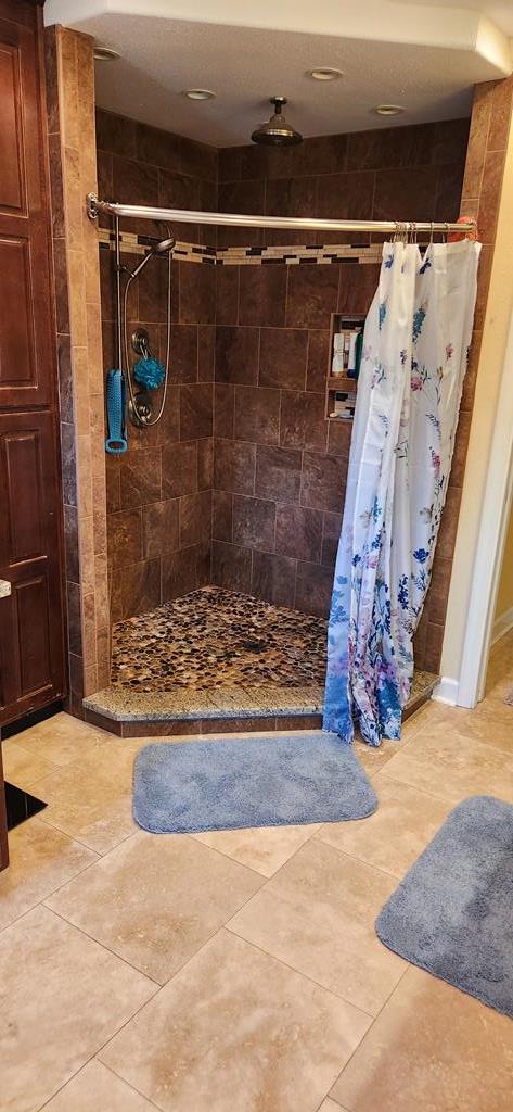 bathroom with tile patterned flooring and walk in shower