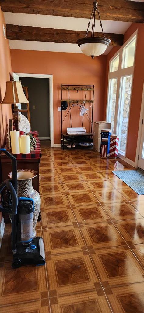 entryway featuring beamed ceiling