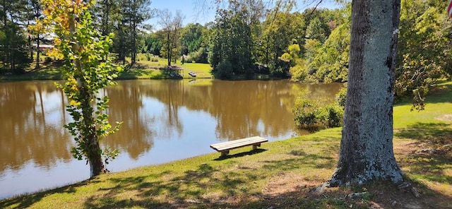 view of property's community with a lawn and a water view