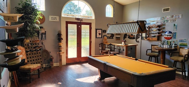 game room with hardwood / wood-style floors, a towering ceiling, french doors, and pool table