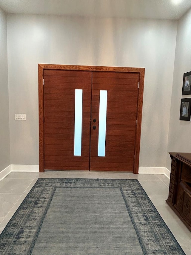 tiled foyer entrance featuring french doors and baseboards