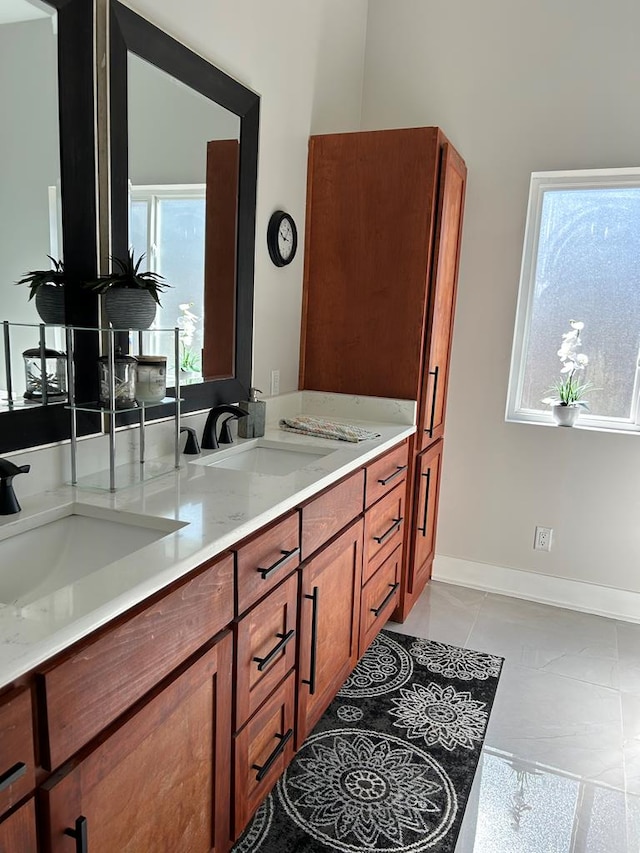 bathroom with a healthy amount of sunlight, baseboards, and a sink