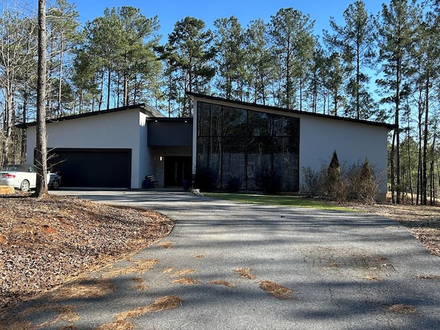 view of front of home with driveway, an attached garage, and stucco siding