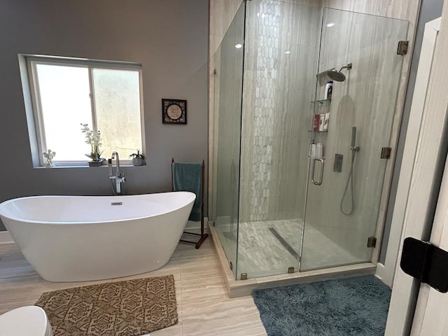 full bathroom featuring a freestanding bath and a shower stall