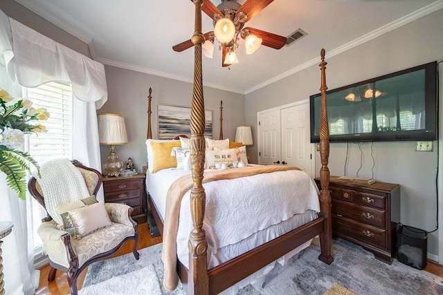 bedroom with wood-type flooring, a closet, ceiling fan, and ornamental molding