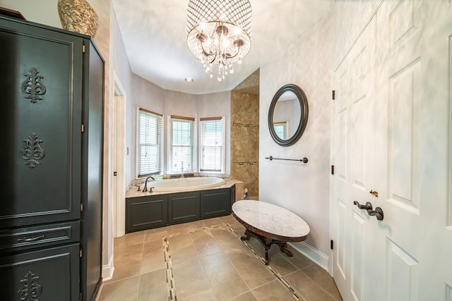 bathroom featuring tile patterned flooring, a tub to relax in, and a chandelier