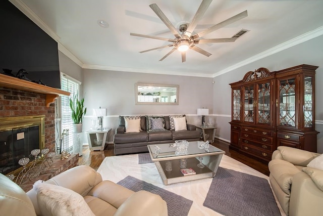 living room with ceiling fan, light wood-type flooring, ornamental molding, and a brick fireplace