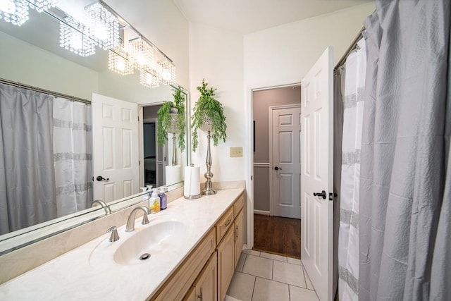 bathroom with tile patterned flooring, vanity, curtained shower, and an inviting chandelier