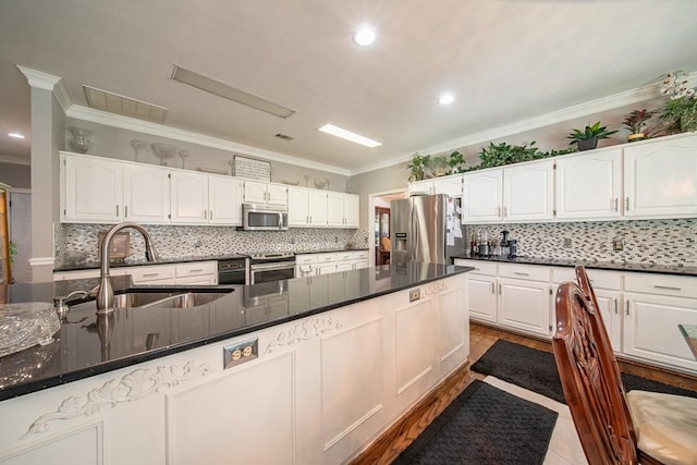 kitchen featuring crown molding, white cabinets, and stainless steel appliances