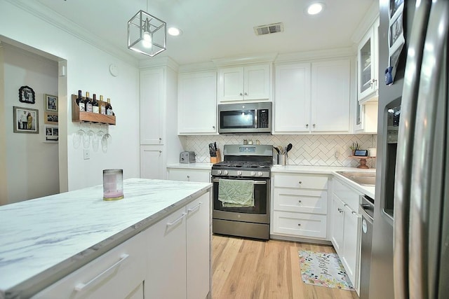 4502 Northwood Ave, Columbus, GA 31907 - kitchen featuring appliances with stainless steel finishes, white cabinetry, decorative backsplash, light wood-style flooring, and recessed lighting