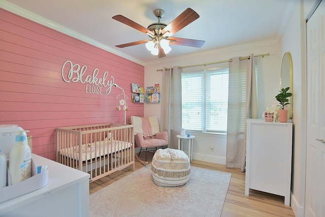 4502 Northwood Ave, Columbus, GA 31907 - bedroom featuring crown molding, a crib, light wood-type flooring, a ceiling fan, and wood walls