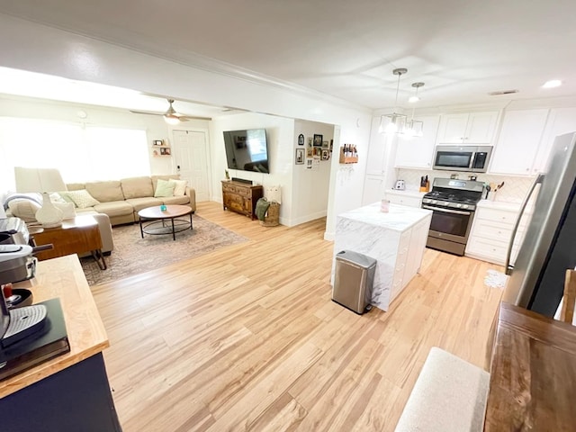 4502 Northwood Ave, Columbus, GA 31907 - kitchen featuring stainless steel appliances, light wood-style flooring, white cabinets, pendant lighting, and a center island
