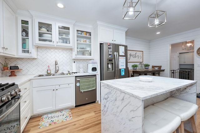 4502 Northwood Ave, Columbus, GA 31907 - kitchen with appliances with stainless steel finishes, white cabinets, a center island, backsplash, and light wood-style flooring