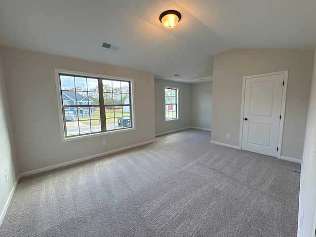 carpeted empty room with lofted ceiling